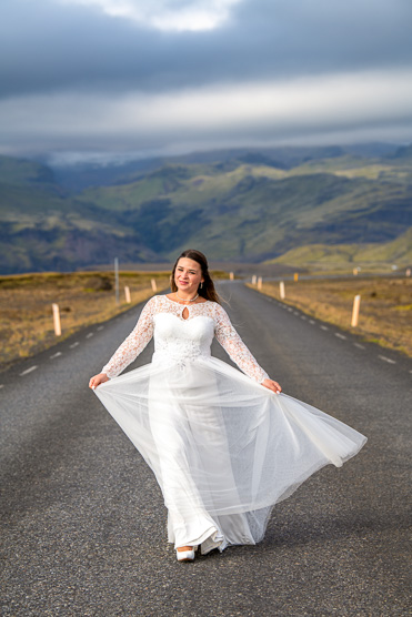 Bride twirling her dress on an open mountain road